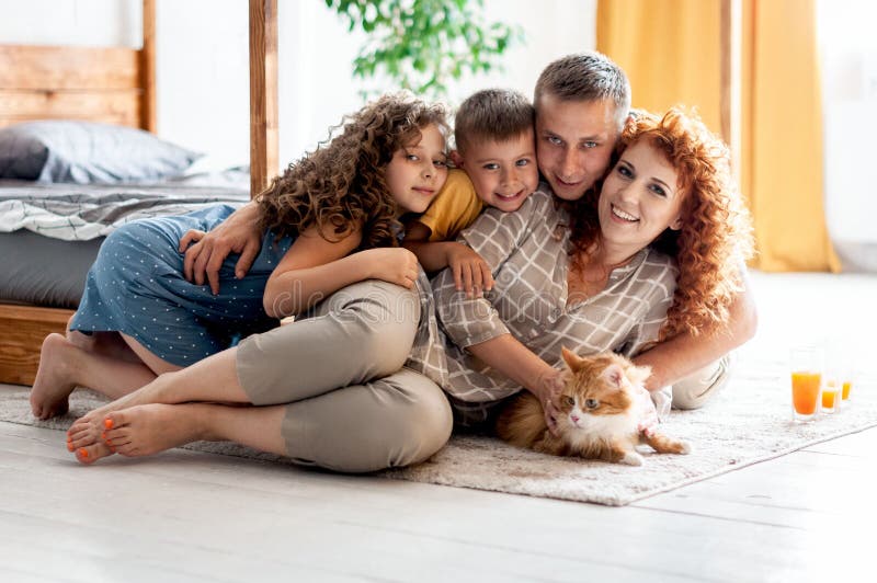 Portrait of a happy young family with two children and red fluffy cat