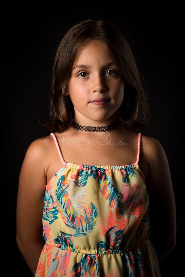 Portrait of happy young little girl with emotions on black