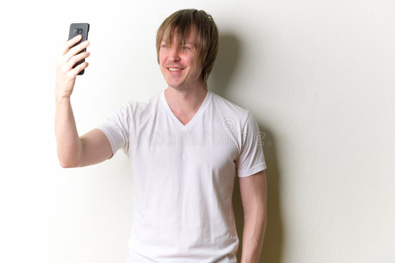 Studio shot of young handsome man with long blond hair against white background. Studio shot of young handsome man with long blond hair against white background