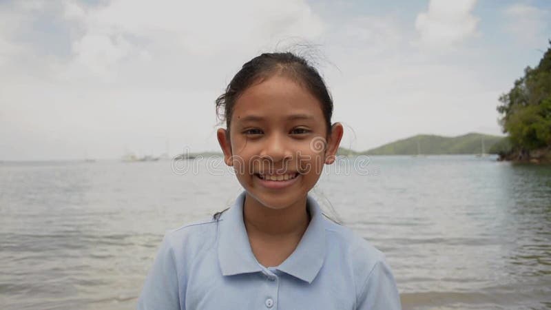 Portrait haut? troit de fille mignonne souriant sur la plage banque de vidéos