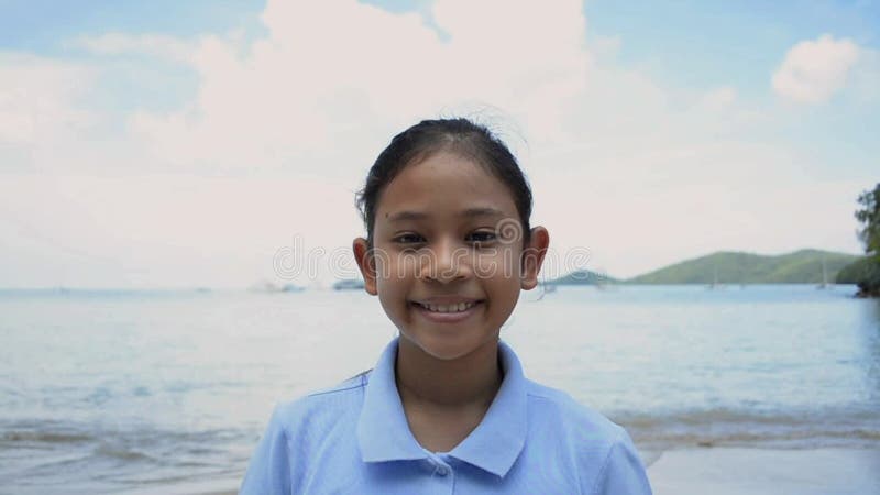 Portrait haut? troit de fille mignonne souriant sur la plage banque de vidéos