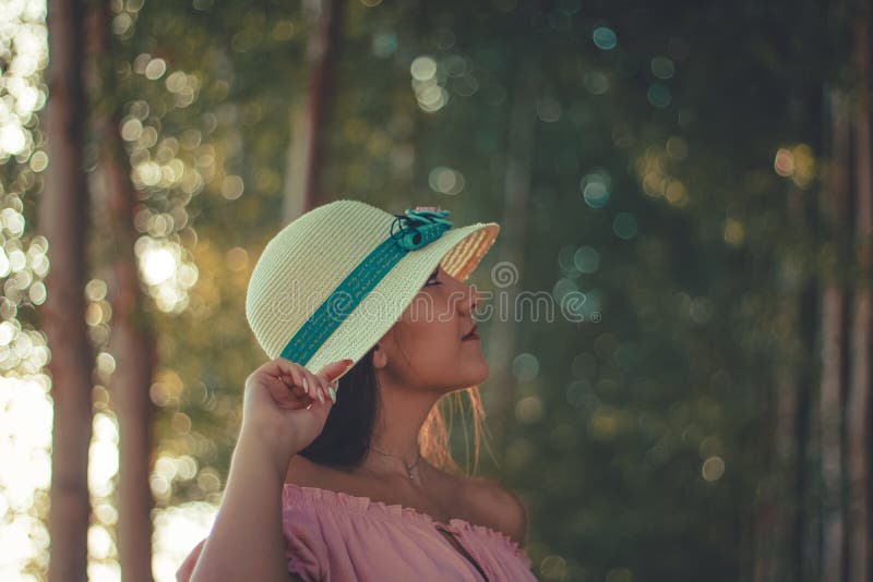 Portrait haut étroit d'une jeune fille portant un chapeau blanc du soleil et une forêt comme fond photographie stock libre de droits Portrait haut étroit d'une jeune fille portant un chapeau blanc du soleil et une forêt comme fond photographie stock libre de droits