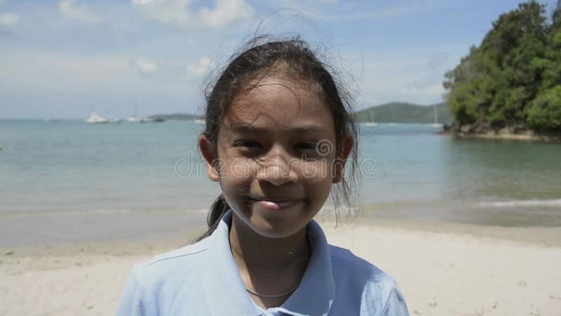 Portrait haut étroit de fille mignonne souriant sur la plage clips vidéos