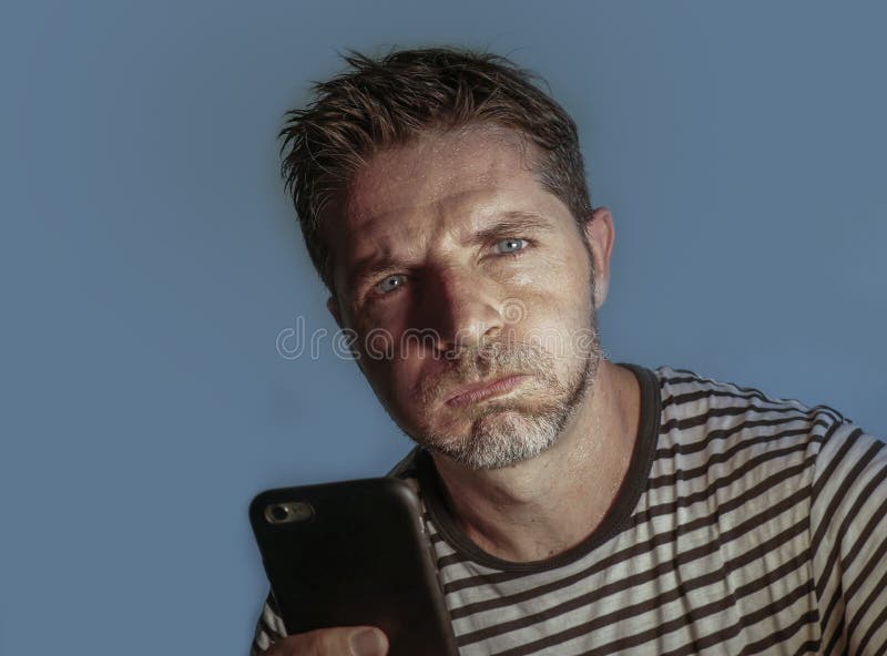 Portrait haut étroit de visage du jeune homme attirant et soumis à une contrainte utilisant le sentiment de téléphone portable in images stock Portrait haut étroit de visage du jeune homme attirant et soumis à une contrainte utilisant le sentiment de téléphone portable in images stock