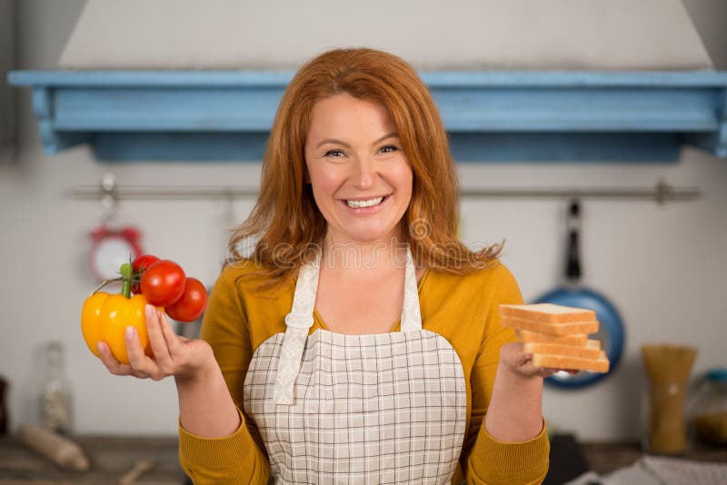 Portrait Of Housewife Holding Vegetables In One Hand And Bread In 