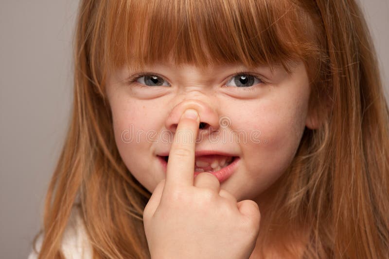 Portrait idiot d'une fille d'une chevelure rouge adorable sur le gris photo stock Portrait idiot d'une fille d'une chevelure rouge adorable sur le gris photo stock