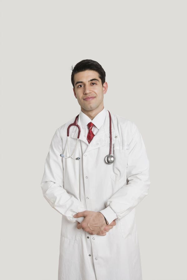 Portrait of an Indian male doctor smiling over gray background stock images Portrait of an Indian male doctor smiling over gray background stock images