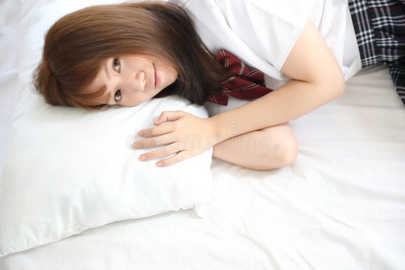 Portrait japanese school girl costume sleeping and smile in white tone bed ...
