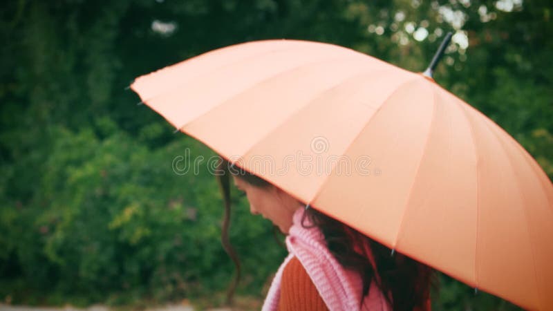 Portrait jeune femme avec parapluie debout dans la pluie gouttes d'eau coulent vers le bas. mauvais temps pluvieux printemps été banque de vidéos