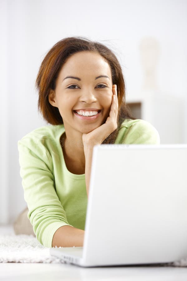 Portrait of laughing ethnic girl with laptop stock photos