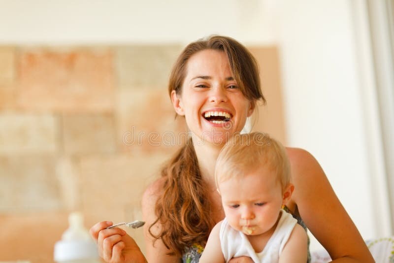 Portrait of laughing young mother feeding baby royalty free stock photos Portrait of laughing young mother feeding baby royalty free stock photos