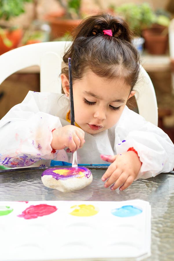 Cute little girl having fun, coloring with brush, playing and painting. Preschooler with paint at garden. stock photos Cute little girl having fun, coloring with brush, playing and painting. Preschooler with paint at garden. stock photos
