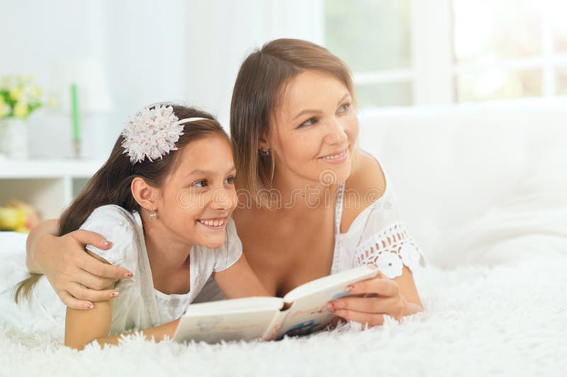 Portrait of little cute girl with mother reading book stock photography Portrait of little cute girl with mother reading book stock photography