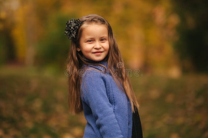Lovely little girl portrait. Smiling kid on blue shirt poses outdoors with  fountain on background. Child innocence, happiness, fashion model concepts  Stock Photo | Adobe Stock