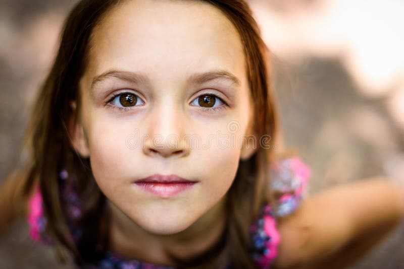 Portrait of little girl looking up at the parent outdoors.