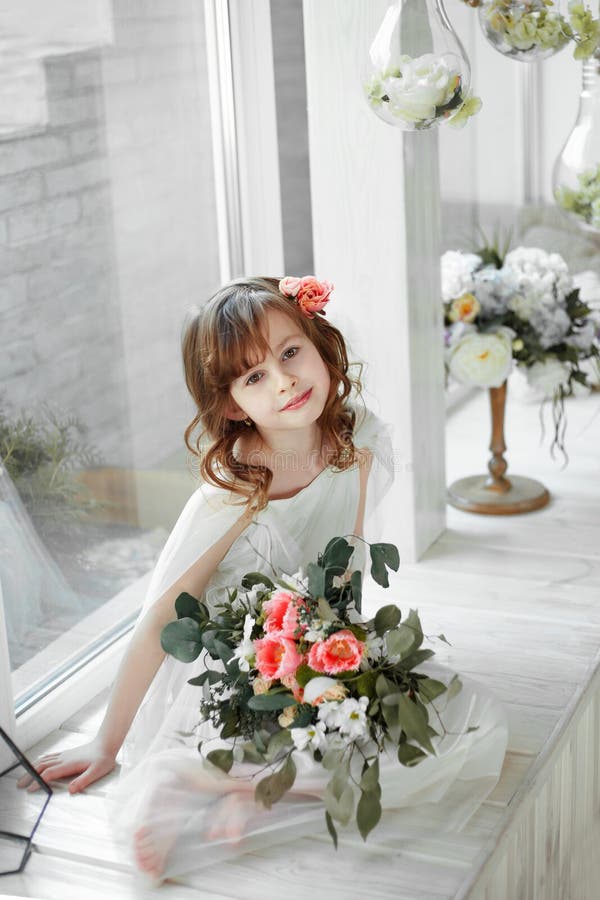 Portrait of little girl sitiing on white wooden window-sill with big light window stock photos Portrait of little girl sitiing on white wooden window-sill with big light window stock photos