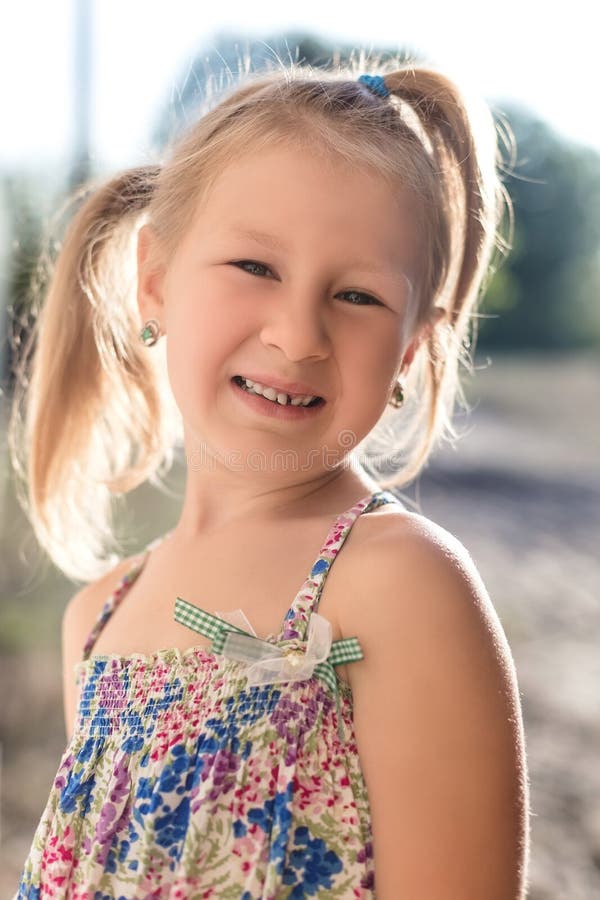 Portrait of a little girl with a wobbly baby tooth