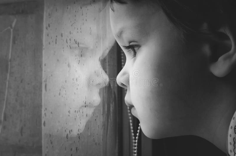 Portrait of a little kid looking in window.