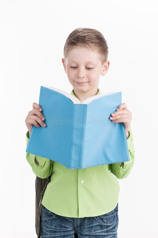 Portrait of little schoolboy with book on white background.