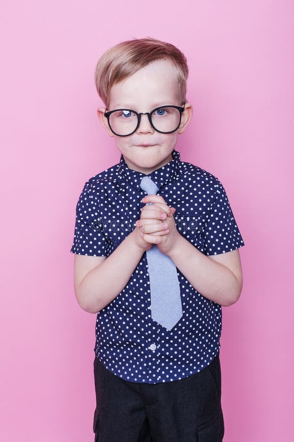 Portrait of a little smiling boy in a funny glasses and tie. School. Preschool. Fashion. Studio portrait over pink background royalty free stock image Portrait of a little smiling boy in a funny glasses and tie. School. Preschool. Fashion. Studio portrait over pink background royalty free stock image