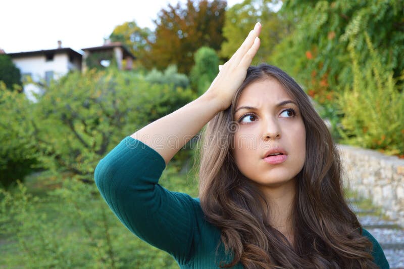 Portrait of lovely brunette woman remembered something and holds a hand