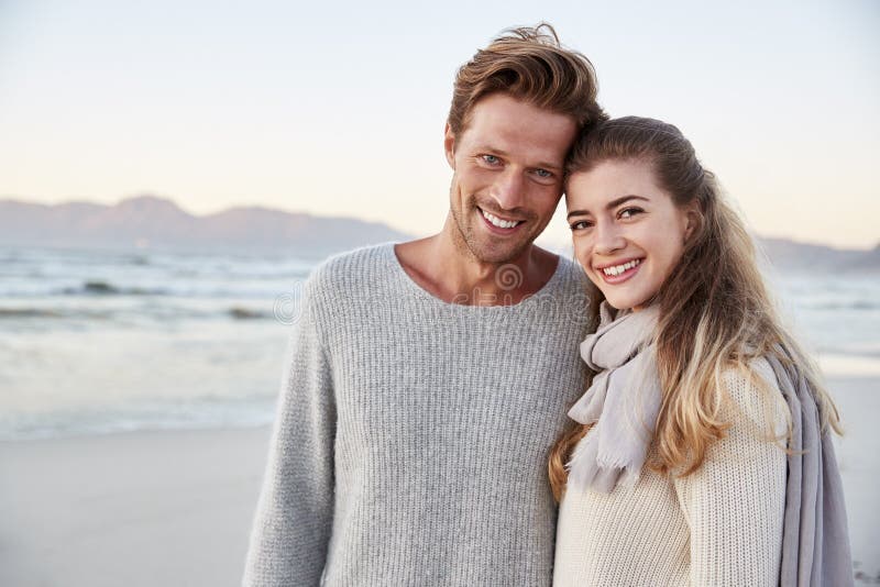 Portrait Of Loving Couple Walking Along Winter Beach Together royalty free stock photography