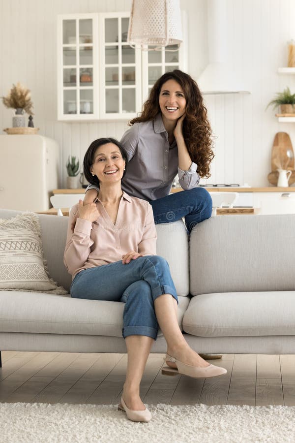 Portrait lächelnd erwachsene Mutter Tochter posiert auf Sofa stockbild