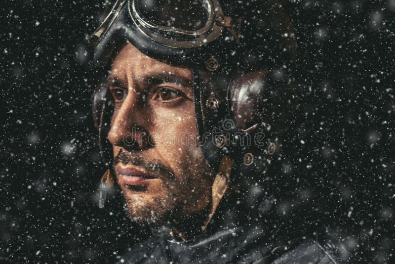 Portrait of a man with aviator helmet and goggles in heavy snow looking into the distance stock image Portrait of a man with aviator helmet and goggles in heavy snow looking into the distance stock image
