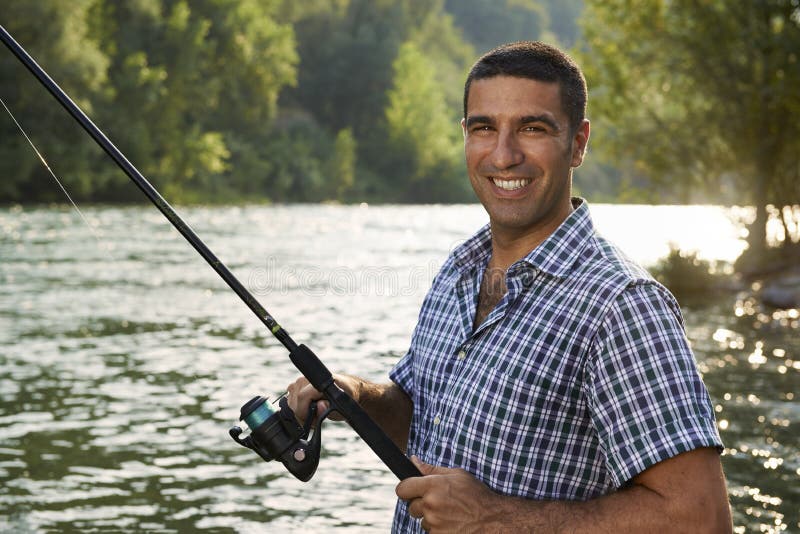 Download Portrait Of Man Fishing On River And Holding Rod Stock ...