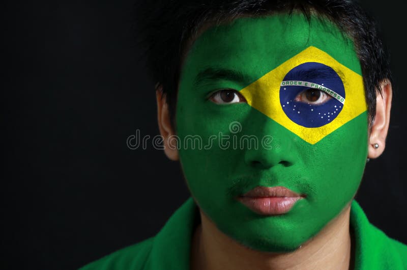 Portrait of a man with the flag of the Brazil painted on his face. stock images Portrait of a man with the flag of the Brazil painted on his face. stock images