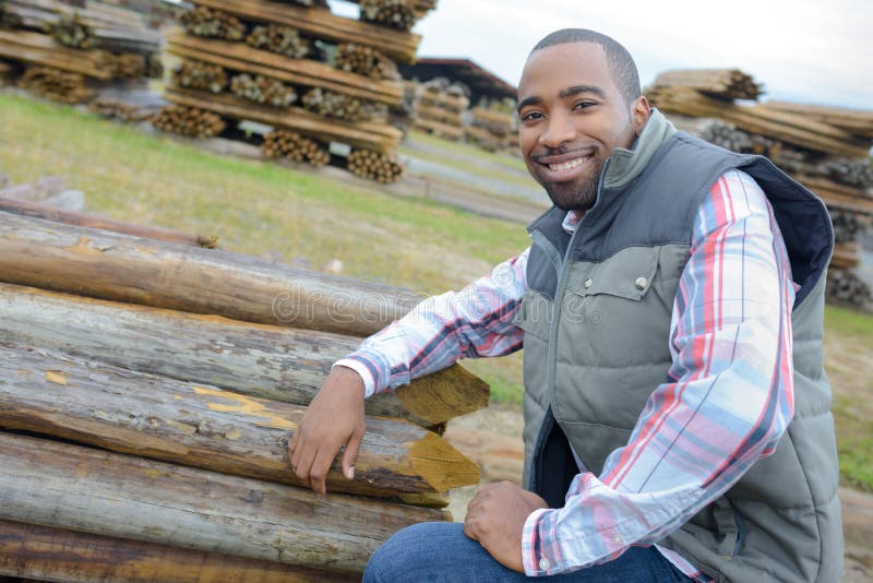 Portrait man next to stack logs royalty free stock photos