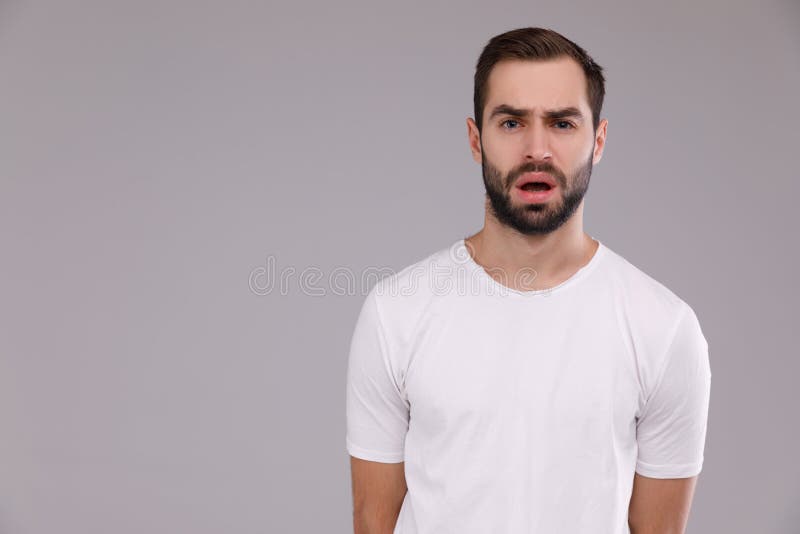 Portrait of a man in a white T-shirt on a gray background stock photography Portrait of a man in a white T-shirt on a gray background stock photography