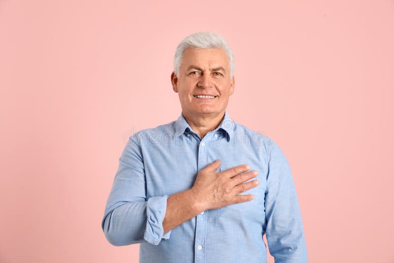 Portrait of mature holding hand on his heart