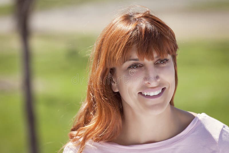 Attractive smiling mature woman red evening stock photo