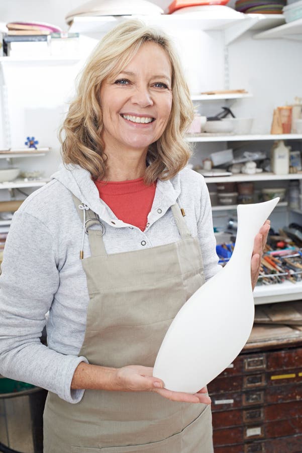 Portrait of Mature Woman Holding Vase in Pottery Studio Stock Image