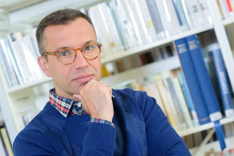 Portrait middle aged man in library stock images