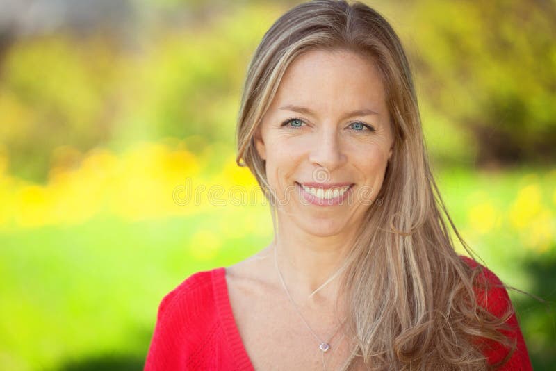 Portrait Of Beautiful Mature Woman With Toothy Smile Standing Outdoor And Looking