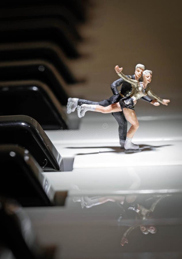 Portrait of a miniature figure Skating couple in the Spotlight on a piano. Portrait of a miniature figure Skating couple in the Spotlight on a piano