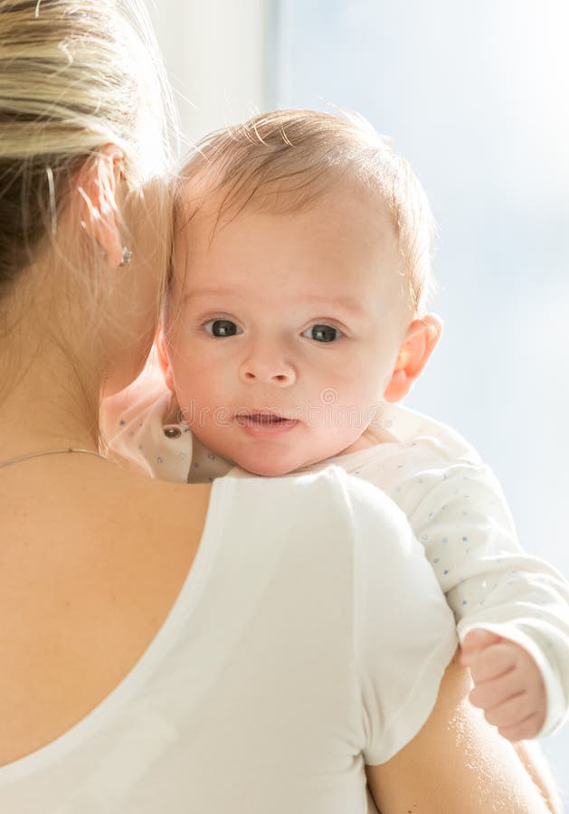 Portrait of 3 months old baby boy hugging mother