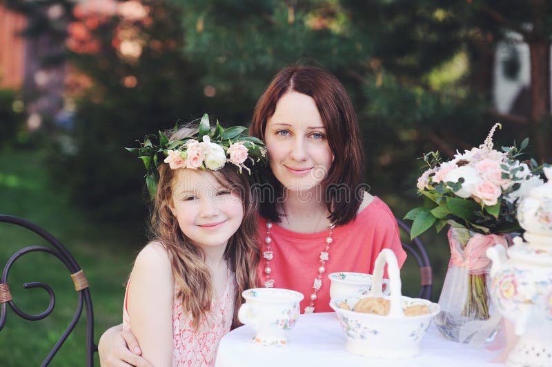 Portrait of mother and daughter at tea table