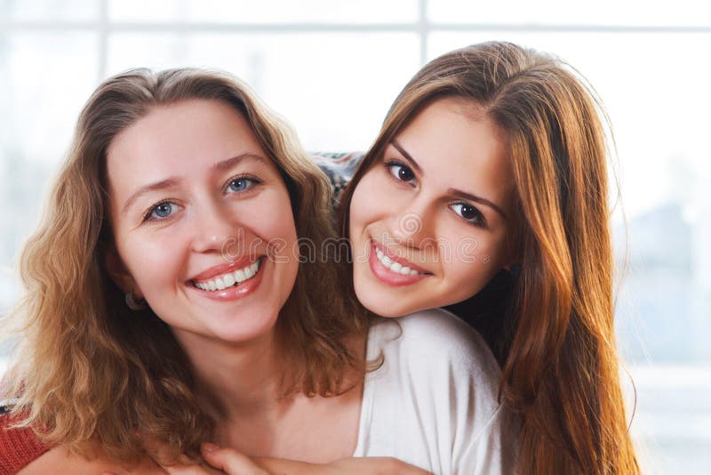 Portrait of a mother and teen daughter being close and hugging