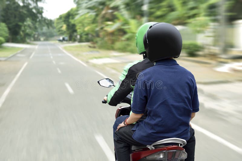 Portrait of motorcycle taxi driver delivering the passenger to h