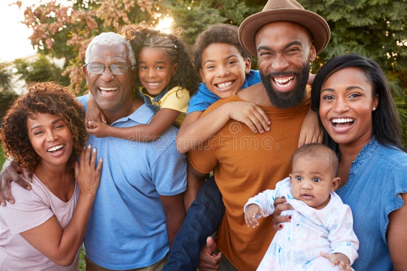 Portrait Of Multi-Generation African American Family Relaxing In Garden At Home Together