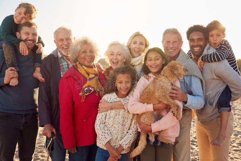 Portrait Of Multi-Generation Family Group With Dog On Winter Beach Vacation stock photography