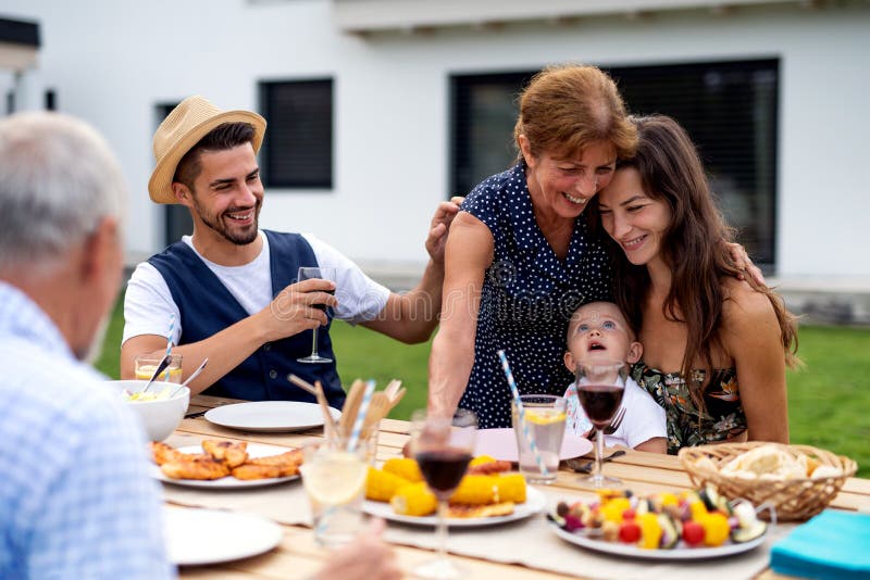 Portrait of Multigeneration Family Sitting at Table Outdoors on Garden ...