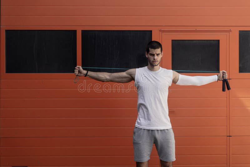 Portrait of muscular young man exercising, stretching with jumping rope stock photos Portrait of muscular young man exercising, stretching with jumping rope stock photos