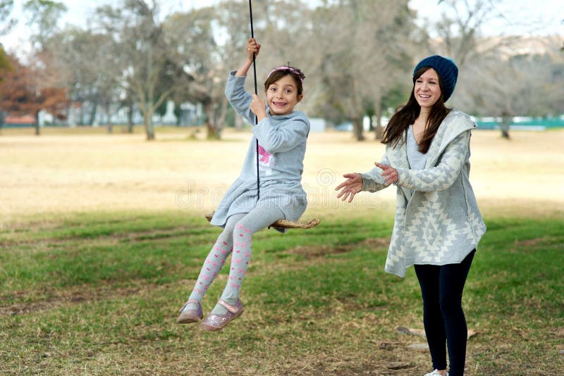 Portrait mère ou enfant en balançoire dans le parc en vacances ou en vacances en hiver avec liberté dans les jeux. aire de jeux po image libre de droits