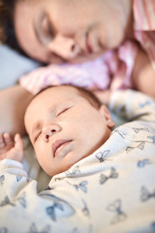 Portrait of newborn baby and mother sleeping on bed, resting together stock images Portrait of newborn baby and mother sleeping on bed, resting together stock images