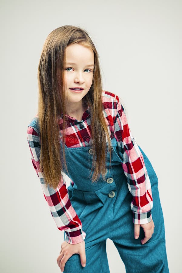 Portrait of a nice little girl. kid smiles. child model posing in the studio. fashion photography stock photos Portrait of a nice little girl. kid smiles. child model posing in the studio. fashion photography stock photos