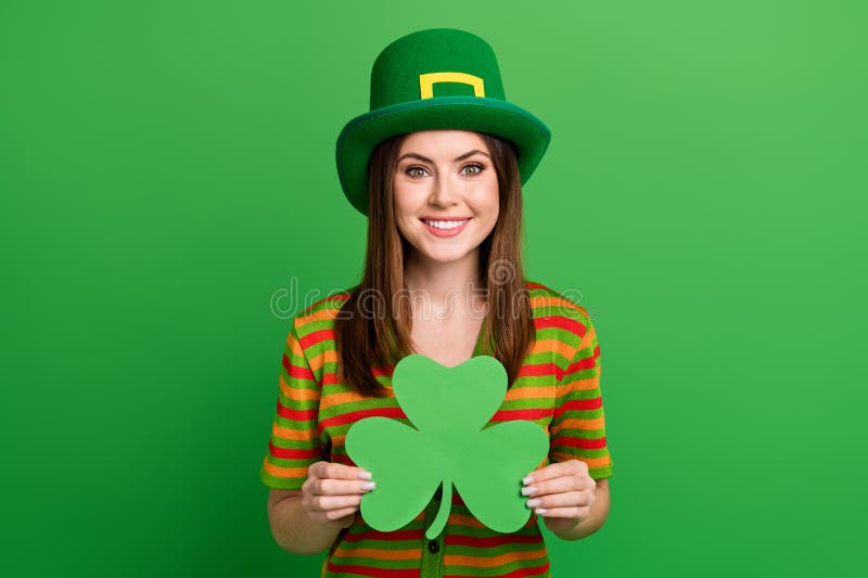 Portrait of nice positive person toothy smile arms hold paper shamrock leaf card isolated on green color background